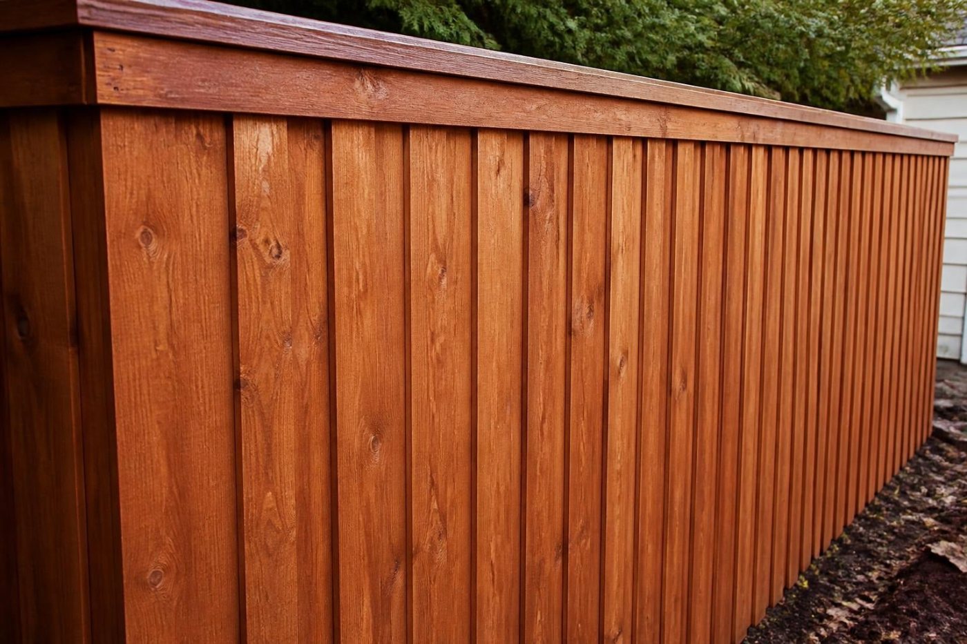 Stained cedar board-on-board privacy fence with a top cap